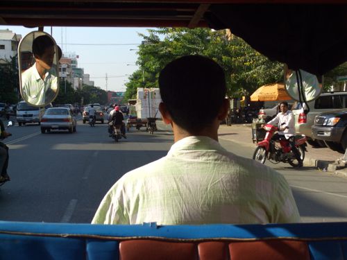 Eine Stra&szlig;e in Phnom Penh im Blickwinkel von einem Tuk-Tuk